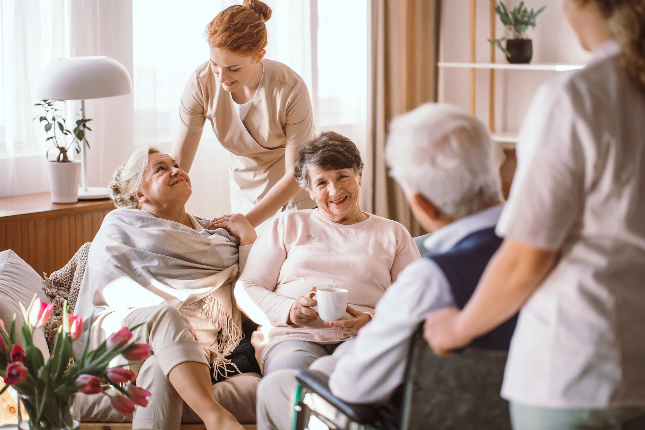 Young caregiver comforting elderly woman in nursing home Young caregiver comforting elderly woman in nursing home